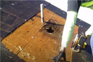 Roofing worker sewing wood flat roof